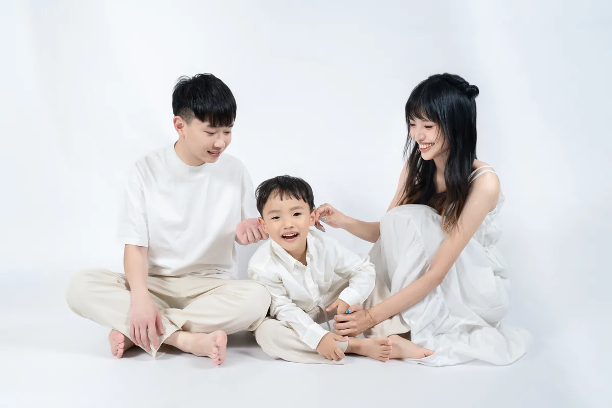 爸爸媽媽與孩子坐在純白背景前自然互動
