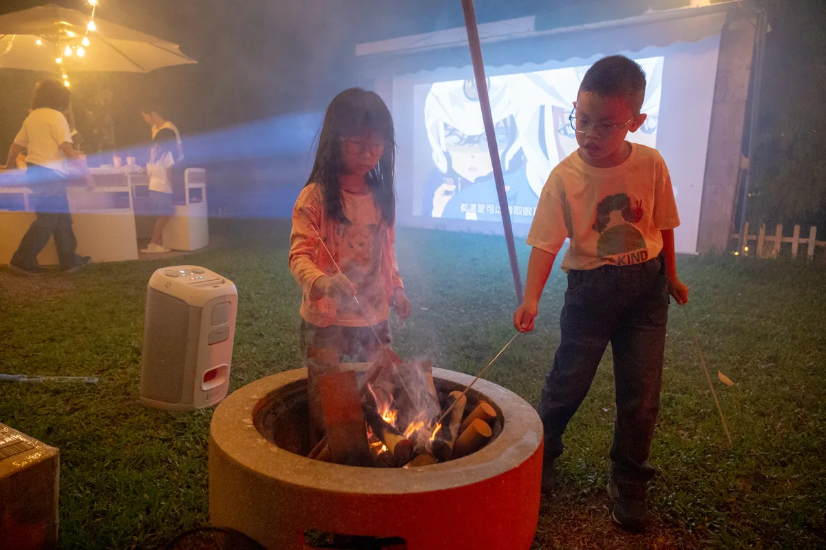 孩子們在戶外投影幕前參與夜間活動