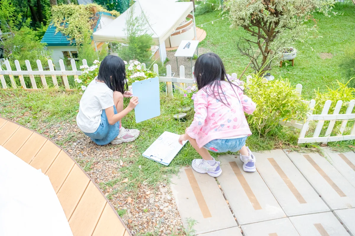 孩子拿著任務單在森林步道尋找英文線索